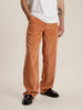 A man wearing vibrant orange corduroy trousers, adding a touch of style and color to his outfit