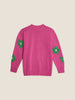 A pink knitted sweater adorned with green flowers, creating a charming and vibrant design.