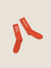 A pair of orange socks with the words 'do it' on them, featuring the additional text 'HOT & WRONG SOCKS'.